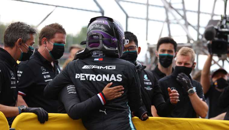 El piloto Lewis Hamilton  es felicitado por el equipo de Mercedes después de ganar la clasificación en Ímola. (Foto Prensa Libre: AFP).