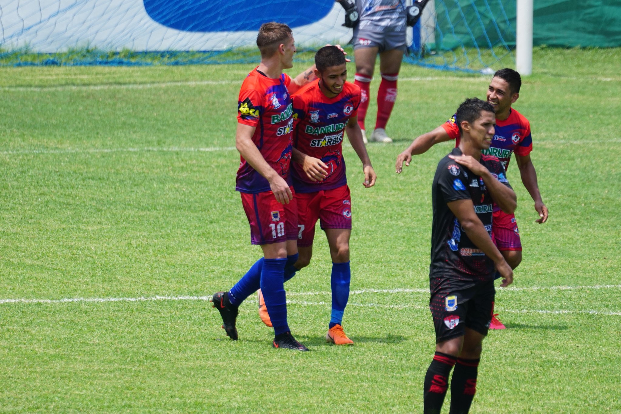 Nelso García es felicitado por sus compañeros en uno de los goles de Iztapa contra Sacachispas. (Foto cortesía AndresNafd).