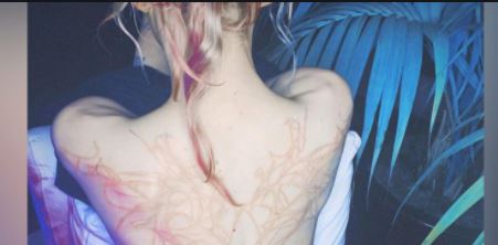 Elon Musk’s partner singer Grimes showing her “alien scars” tattoo