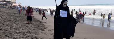 Joven retalteco decidió ir a las playas de Retalhuleu vestido como "La muerte" para llevar un mensaje sobre el coronavirus. (Foto Prensa Libre: Victoria Ruiz)