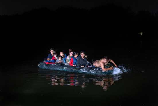 Un traficante de personas lleva en balsas a un grupo de familias inmigrantes a través de la frontera entre Estados Unidos y México en Roma, Texas. (Foto Prensa Libre: AFP)