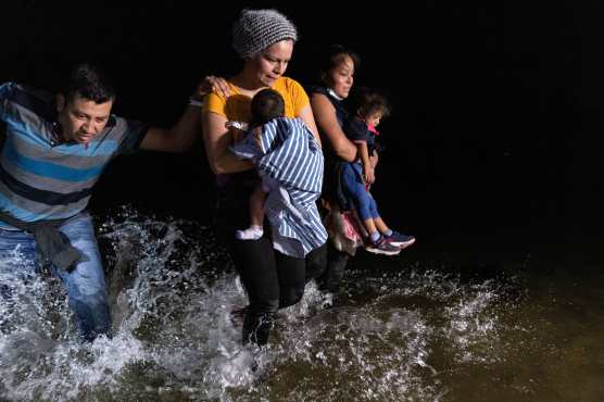 Una familia de El Salvador camina hacia la orilla del Río Grande en la frontera entre Estados Unidos y México en Roma, Texas.  (Foto Prensa Libre: AFP)