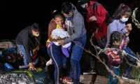 ROMA, TEXAS - APRIL 14: Parents check on their infant on the bank of the Rio Grande after they were smuggled across the U.S.-Mexico border on April 14, 2021 in Roma, Texas. A surge of mostly Central American immigrants crossing into the United States, including record numbers of children, has challenged U.S. immigration agencies along the U.S. southern border.   John Moore/Getty Images/AFP
== FOR NEWSPAPERS, INTERNET, TELCOS & TELEVISION USE ONLY ==
