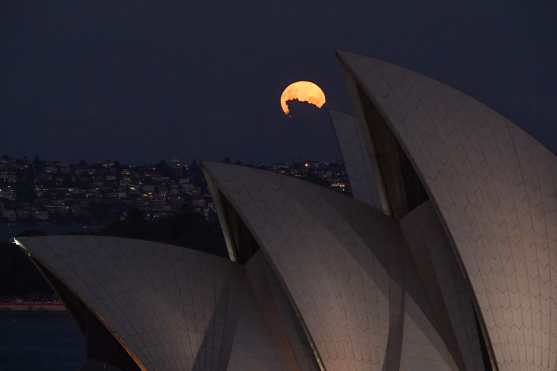 La superluna rosa se eleva detrás de las velas de la ópera de Sydney, Australia. (Foto Prensa Libre: EFE)
