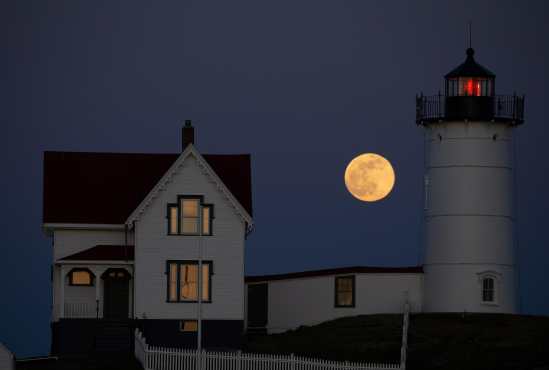 La Superluna rosa se observa detrás del Faro Nubble en Cabo Neddick, en York, Maine, Estados Unidos. (Foto Prensa Libre: EFE)
