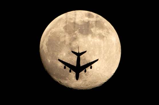 Un avión para frente a la luna en la ciudad de Basora, en el sur de Irak. (Foto Prensa Libre: AFP)