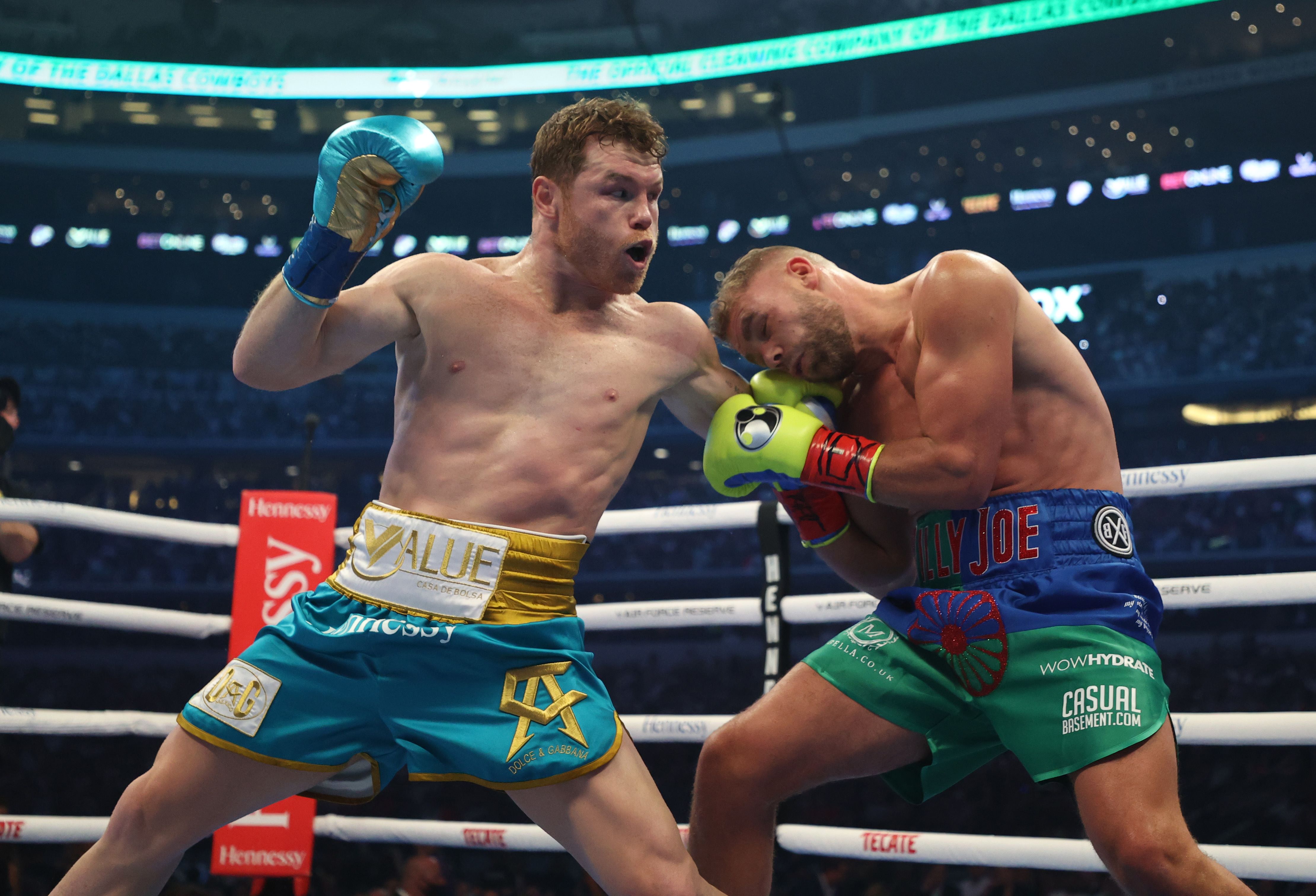 ARLINGTON, TEXAS - MAY 08: Canelo Alvarez punches Billy Joe Saunders during their fight for Alvarez's WBC and WBA super middleweight titles and Saunders' WBO super middleweight title at AT&T Stadium on May 08, 2021 in Arlington, Texas. Al Bello/Getty Images/AFP == FOR NEWSPAPERS, INTERNET, TELCOS & TELEVISION USE ONLY ==