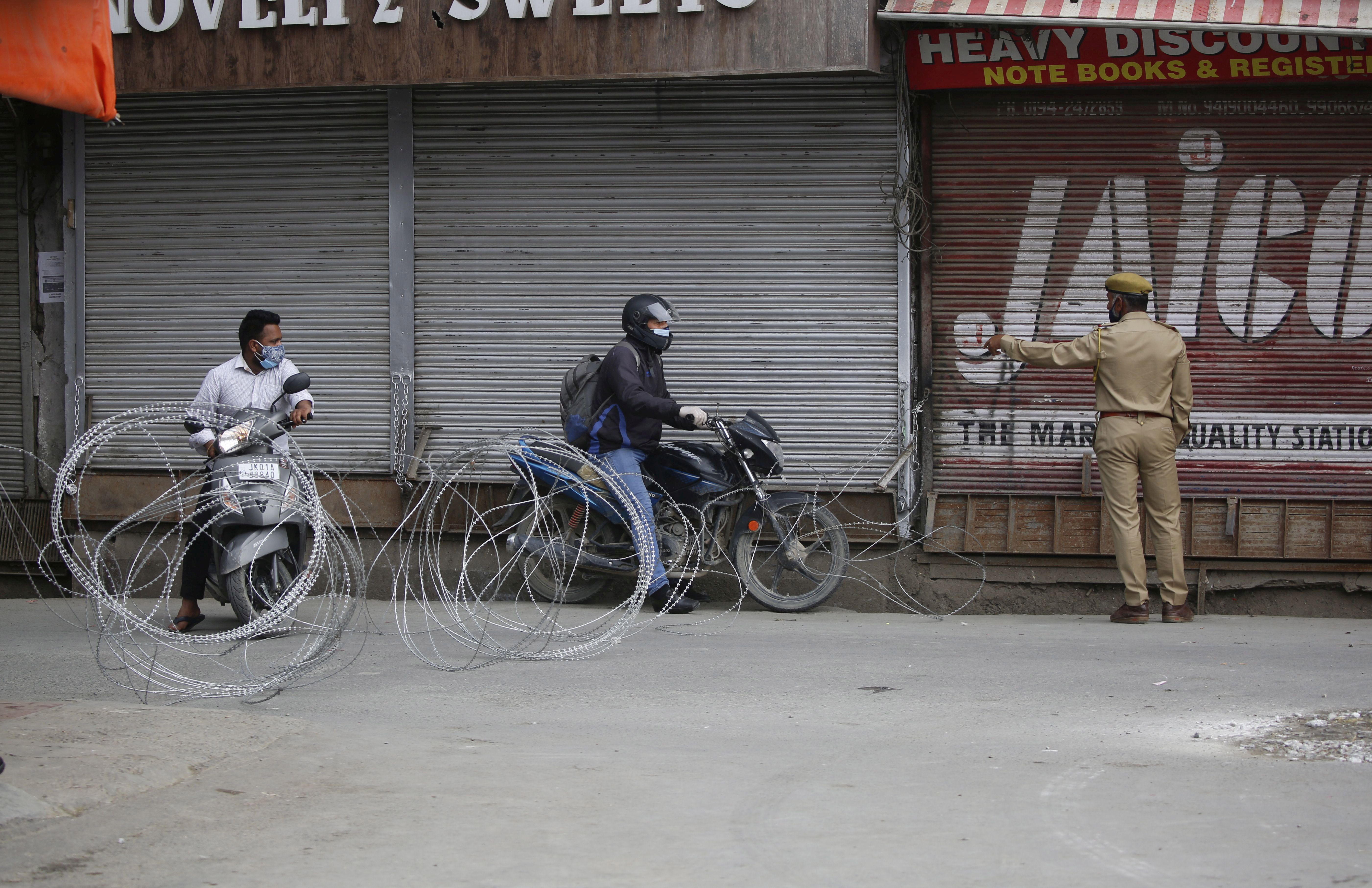 Srinagar (India), 06/05/2021.- Indian policemen stop people during lockdown in Srinagar, the summer capital of Indian Kashmir, 06 May 2021. Officials announced on 06 May that the Coronavirus death toll has now reached 2539 after 29 COVID19 patients lost their lives on 05 May. In view of the rising COVID-19 cases and to contain its spread, the government extended the curfew till 10 May 2021 in four districts of Jammu and Kashmir including Srinagar and Jammu. EFE/EPA/FAROOQ KHAN