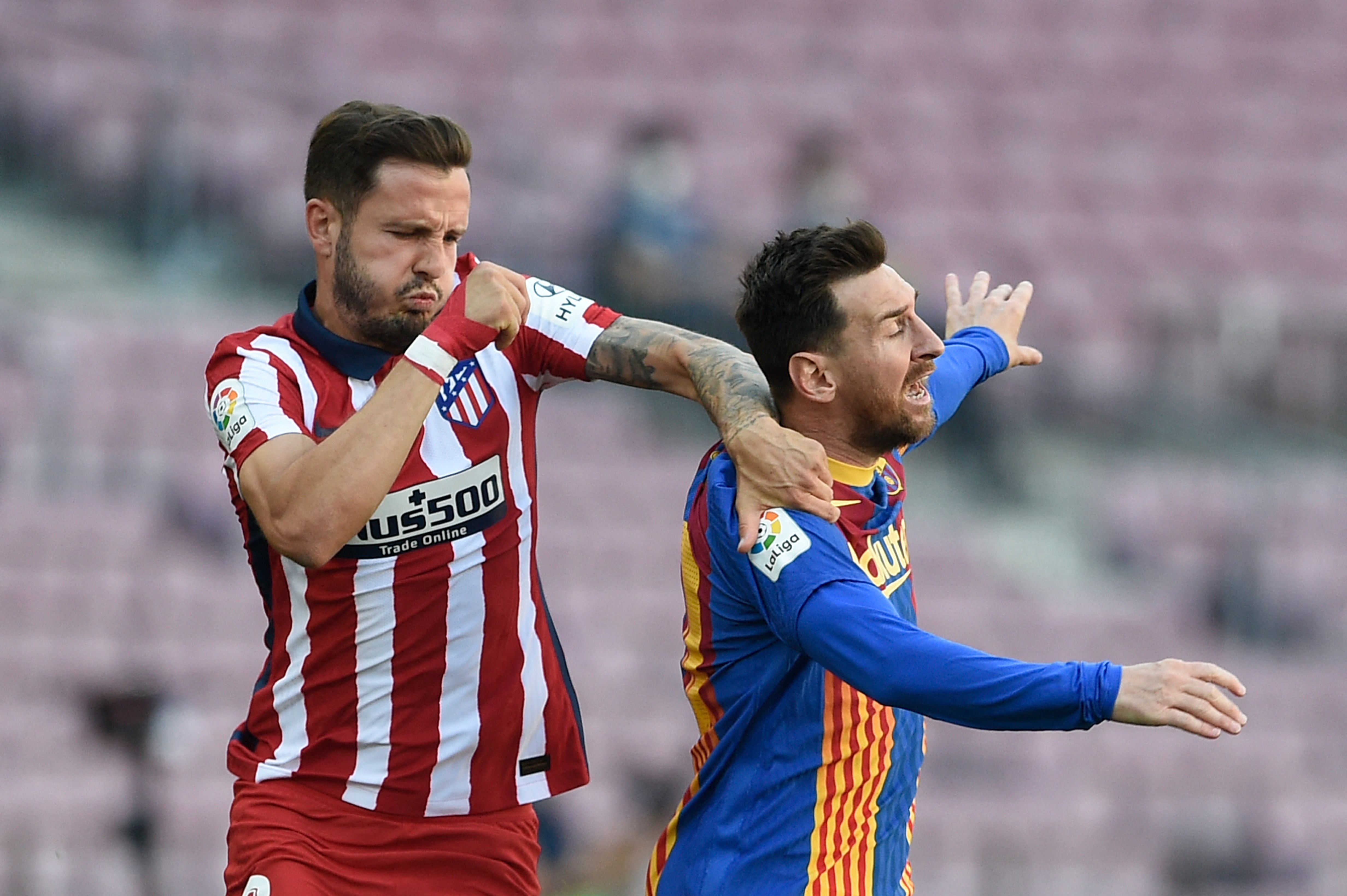 Atletico Madrid's Spanish midfielder Saul Niguez (L) vies for the ball with Barcelona's Argentinian forward Lionel Messi (C) during the Spanish league football match FC Barcelona against Club Atletico de Madrid at the Camp Nou stadium in Barcelona on May 8, 2021. (Photo by Josep LAGO / AFP)