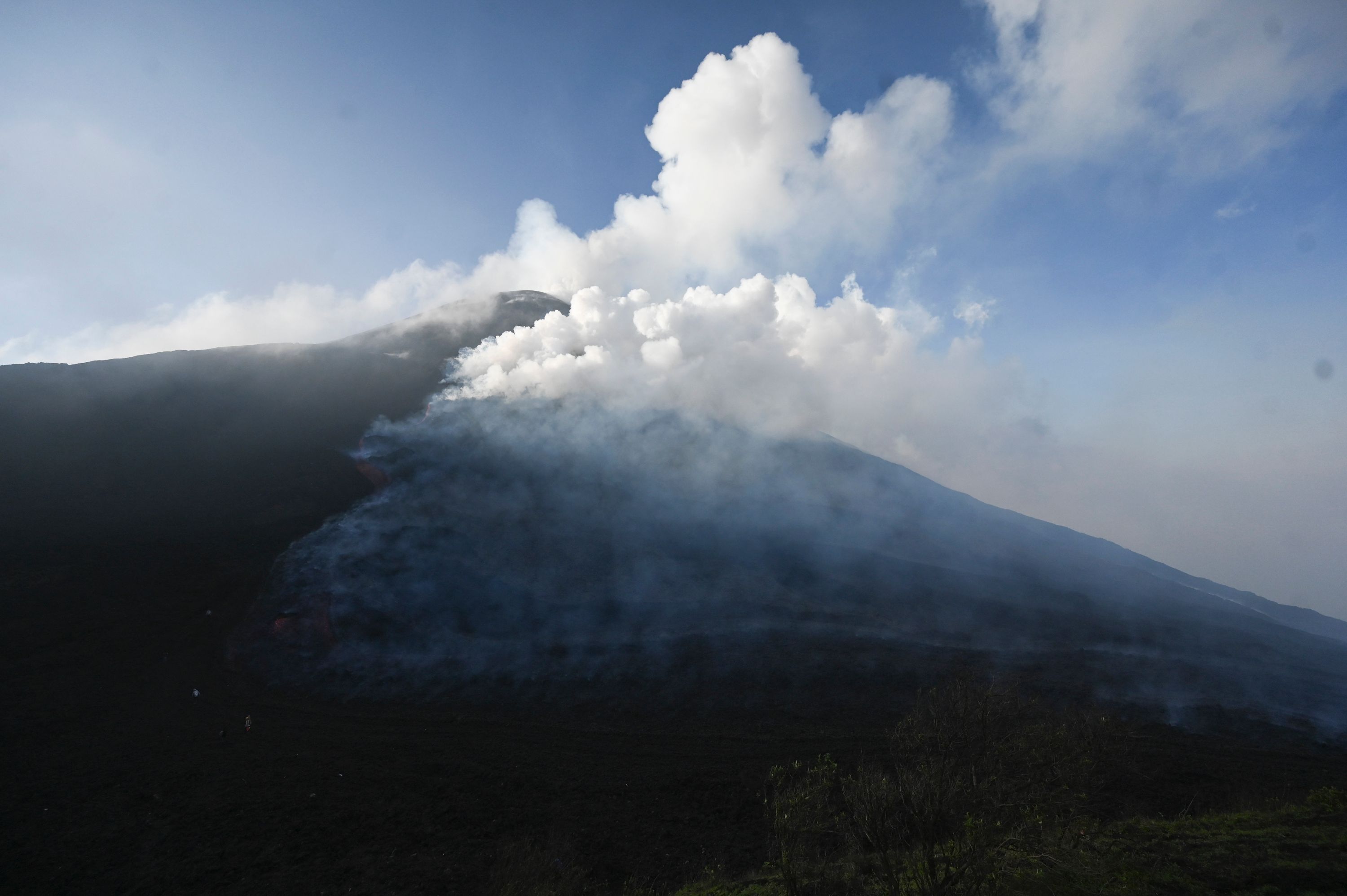 Lava flows from Guatemala's Pacaya Volcano as seen from Cerro Chino hill in San Vicente Pacaya municipality, Guatemala on May 11, 2021. - Garcia makes a pizza in a very particular oven: an extensive river of lava that springs from the furious Pacaya volcano. (Photo by Johan ORDONEZ / AFP)