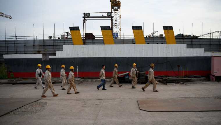 Foto tomada el 27 de abril de 2021 muestra a trabajadores llegando al lugar donde se encuentra la réplica del barco Titanic, aún en construcción, en el condado de Daying, en la provincia suroccidental china de Sichuan. (Foto Prensa Libre: AFP)