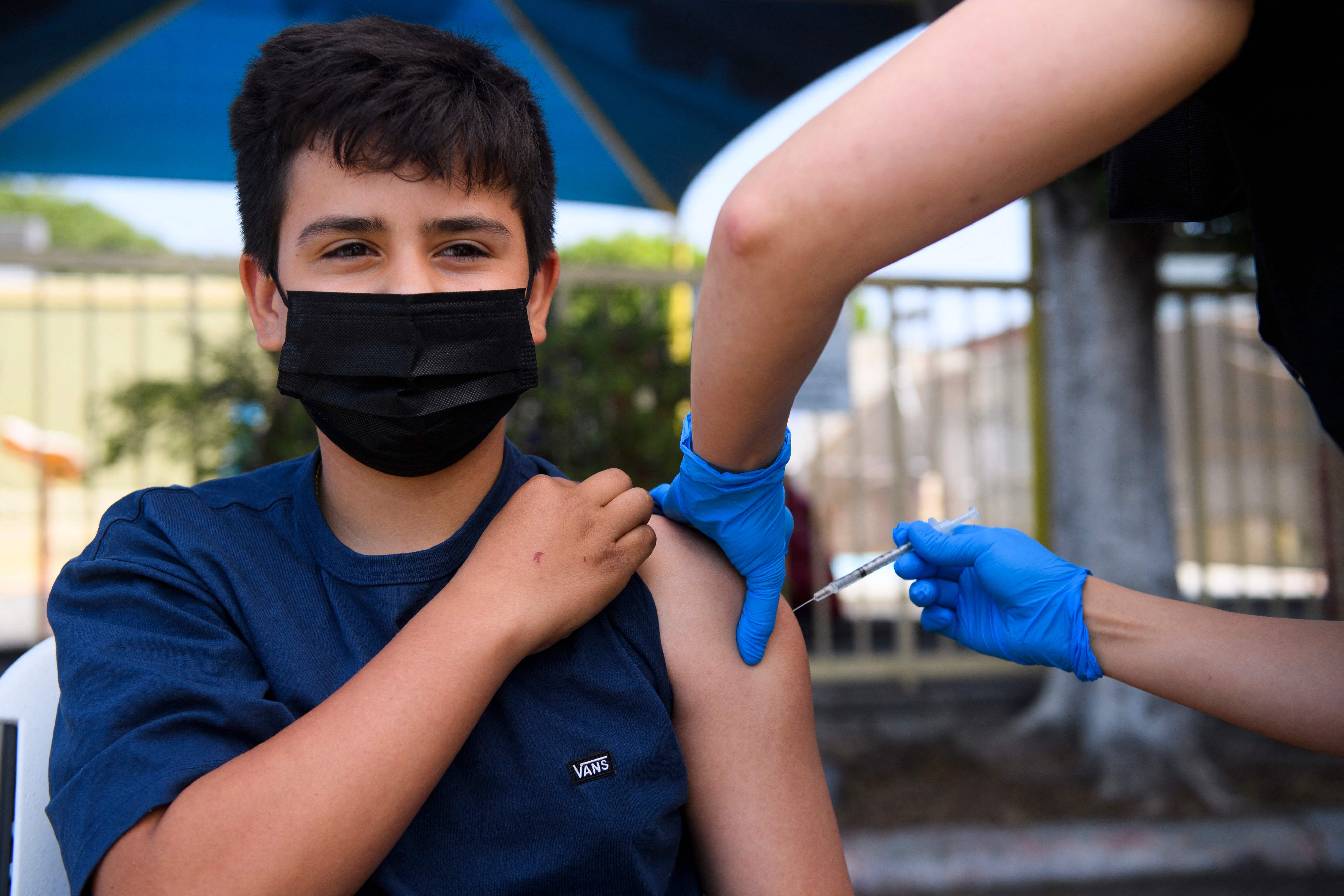 Simon Huizar, de 13 años, recibe la primera dosis de la vacuna de Pfizer en una clínica de Los Ángeles. (Foto Prensa Libre: AFP)