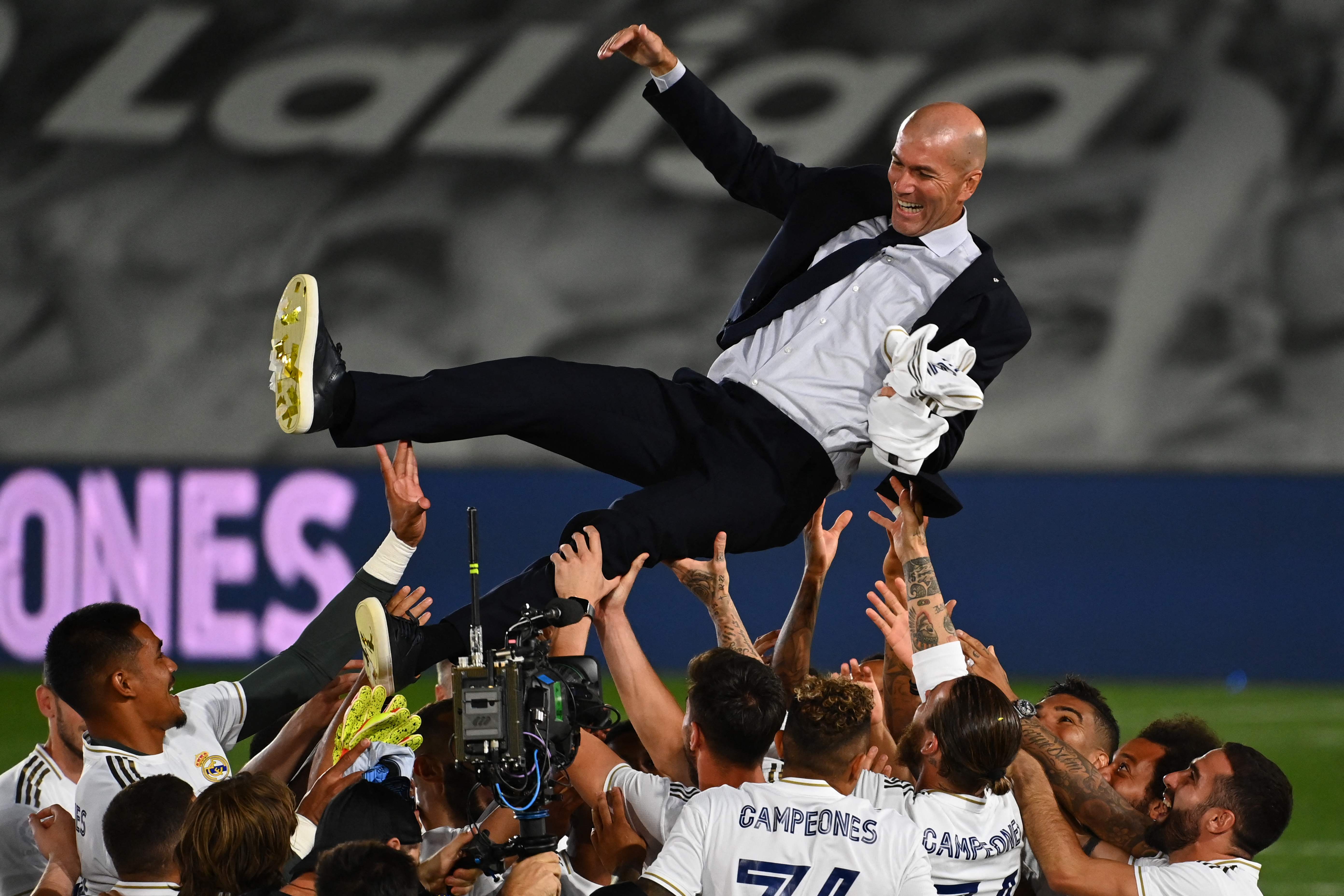 (FILES) In this file photo taken on July 16, 2020 Real Madrid's player toss Real Madrid's French coach Zinedine Zidane after winning the Liga title after the Spanish League football match between Real Madrid CF and Villarreal CF at the Alfredo di Stefano stadium in Valdebebas, on the outskirts of Madrid. - According to media reports, Zinedine Zidane has resigned as Real Madrid manager with immediate effect, just days after the club were beaten to the La Liga title by Atletico Madrid. The Frenchman's reported departure comes at the end of a disappointing campaign for the 13-time European champions, who also lost to Chelsea in the Champions League semi-finals as they failed to win a trophy for the first time in 11 seasons. (Photo by GABRIEL BOUYS / AFP)