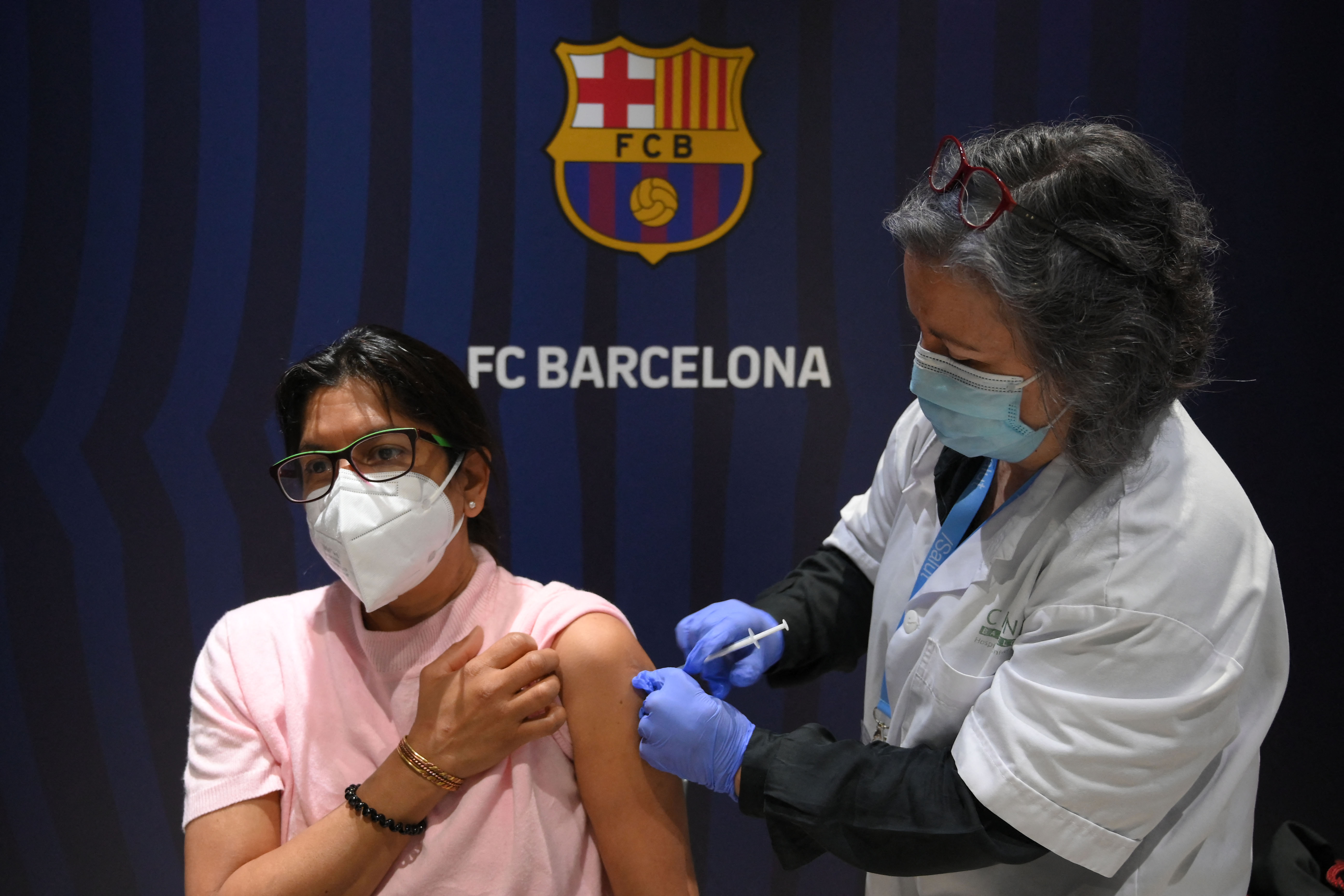Una mujer recibe la vacuna de Pfizer-BioNTech durante la campaña de inmunización contra el covid-19 en el Camp Nou ,estadio del FC Barcelona. Foto Prensa Libre: AFP.