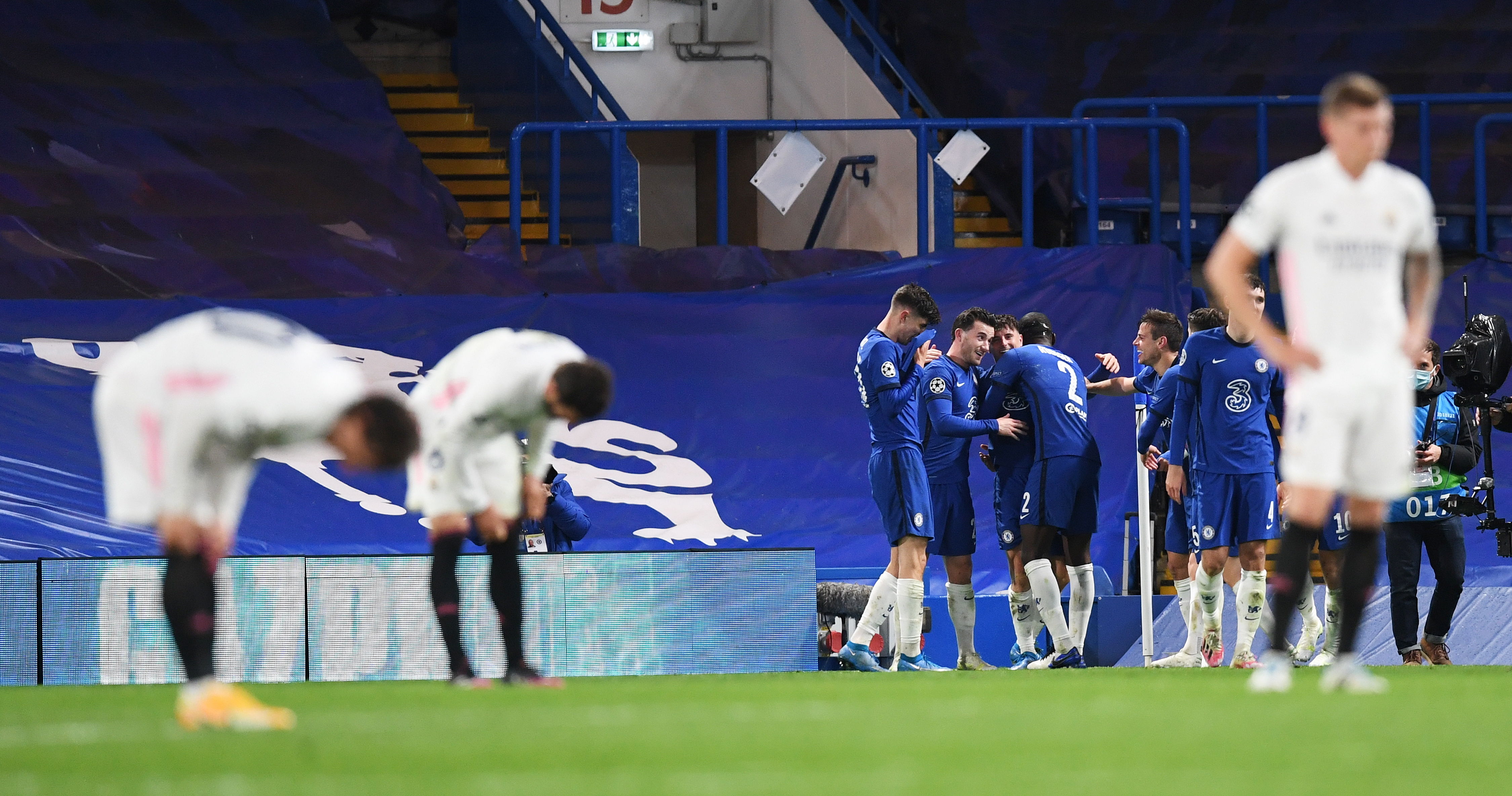 Los jugadores del Chelsea celebran la clasificación al final del partido, mientras los futbolistas merengues se lamentan. (Foto Prensa Libre: EFE)