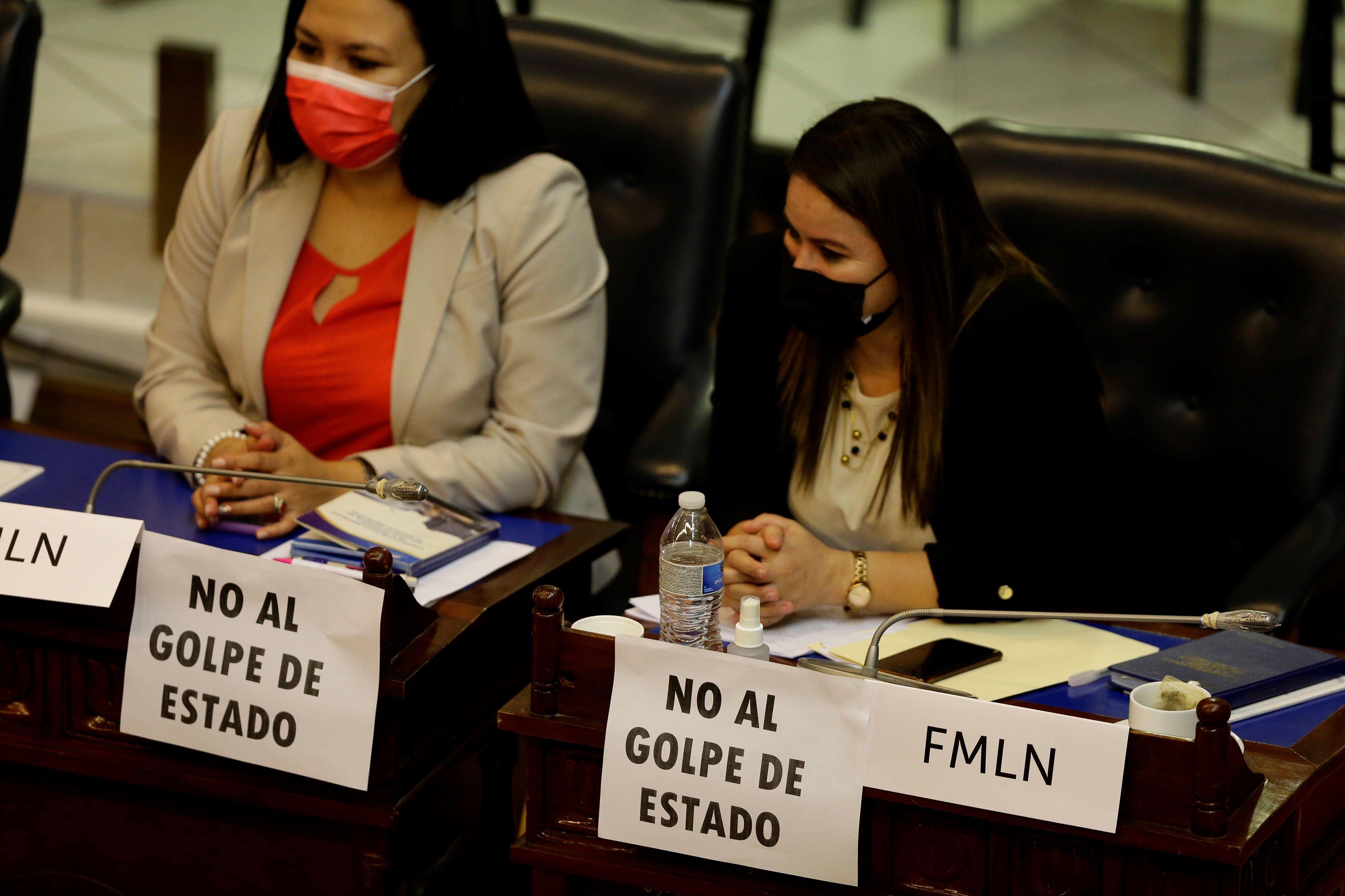 Diputadas del opositor Frente Farabundo Martí para la Liberación Nacional (FMLN) muestran unos carteles en protesta contra las destituciones en el Supremo de El Salvador. (Foto Prensa Libre: EFE)