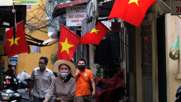 Hanoi (Viet Nam), 25/05/2021.- People wearing face masks walk in an alley in Hanoi, Vietnam, 25 May 2021. Hanoi shut down restaurants, hair salons and barbershops on 25 May in oder to prevent the spread of COVID-19 pandemic. EFE/EPA/LUONG THAI LINH