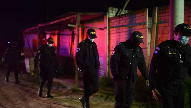 Policías son vistos durante el traslado de los cuerpos de los siete reos asesinados en Cantel, Quetzaltenango. (Foto Prensa Libre: EFE) 