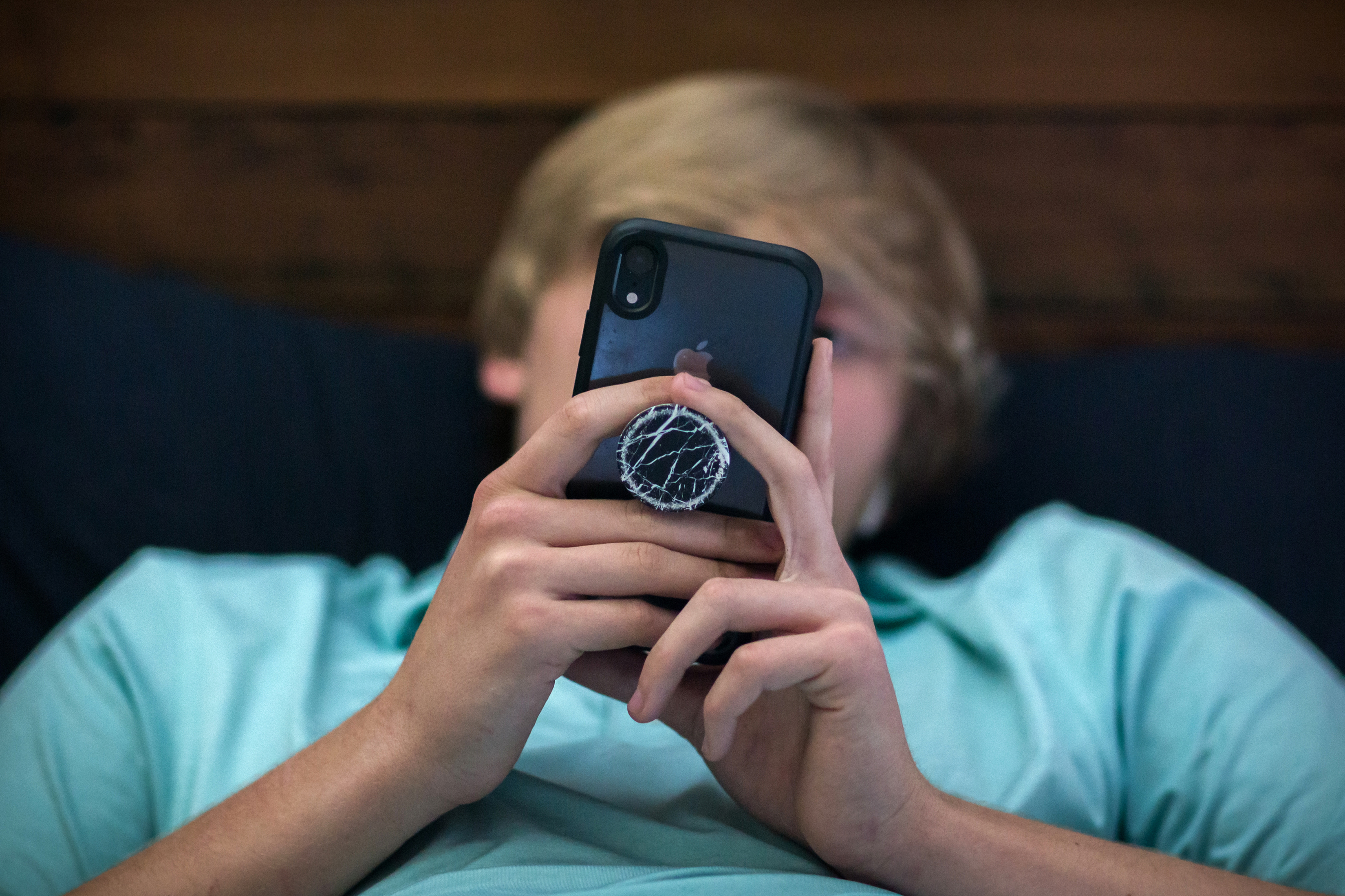 Bo Deal, un estudiante de primer año de secundaria en Metter, Georgia, mira su teléfono en su casa el 26 de marzo de 2021. Su familia restringió el uso de entretenimiento electrónico, excepto por su teléfono celular. (Stephen B. Morton/The New York Times)
