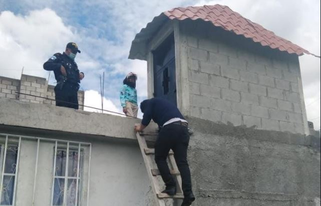 Agentes rescatan a la menor por una pequeña ventana de la terraza de la vivienda. (Foto: PNC)