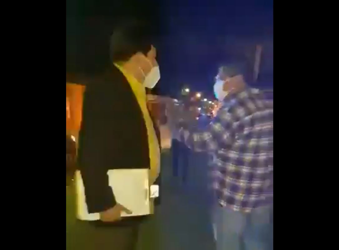 Osiel Calderón , juez nocturno de Asuntos Municipales de Antigua Guatemala, Sacatepéquez, izquierda, encara al vecino con el que discutía durante un operativo. (Foto Prensa Libre: Captura de video)