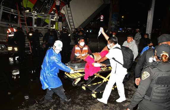 Miembros de los servicios de emergencia trasladan a una de las heridas tras el colapso de los vagones del metro  en la Ciudad de México. (Foto Prensa Libre: EFE)