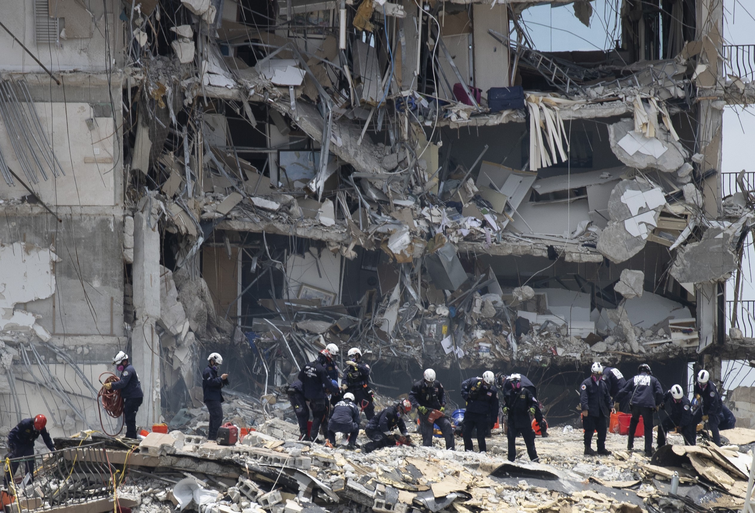 SURFSIDE, FLORIDA - JUNE 26: Members of the South Florida Urban Search and Rescue team look for possible survivors in the partially collapsed 12-story Champlain Towers South condo building on June 26, 2021 in Surfside, Florida. Over 150 people are being reported as missing as search-and-rescue efforts continue with rescue crews from across Miami-Dade and Broward counties. Joe Raedle/Getty Images/AFP == FOR NEWSPAPERS, INTERNET, TELCOS & TELEVISION USE ONLY ==