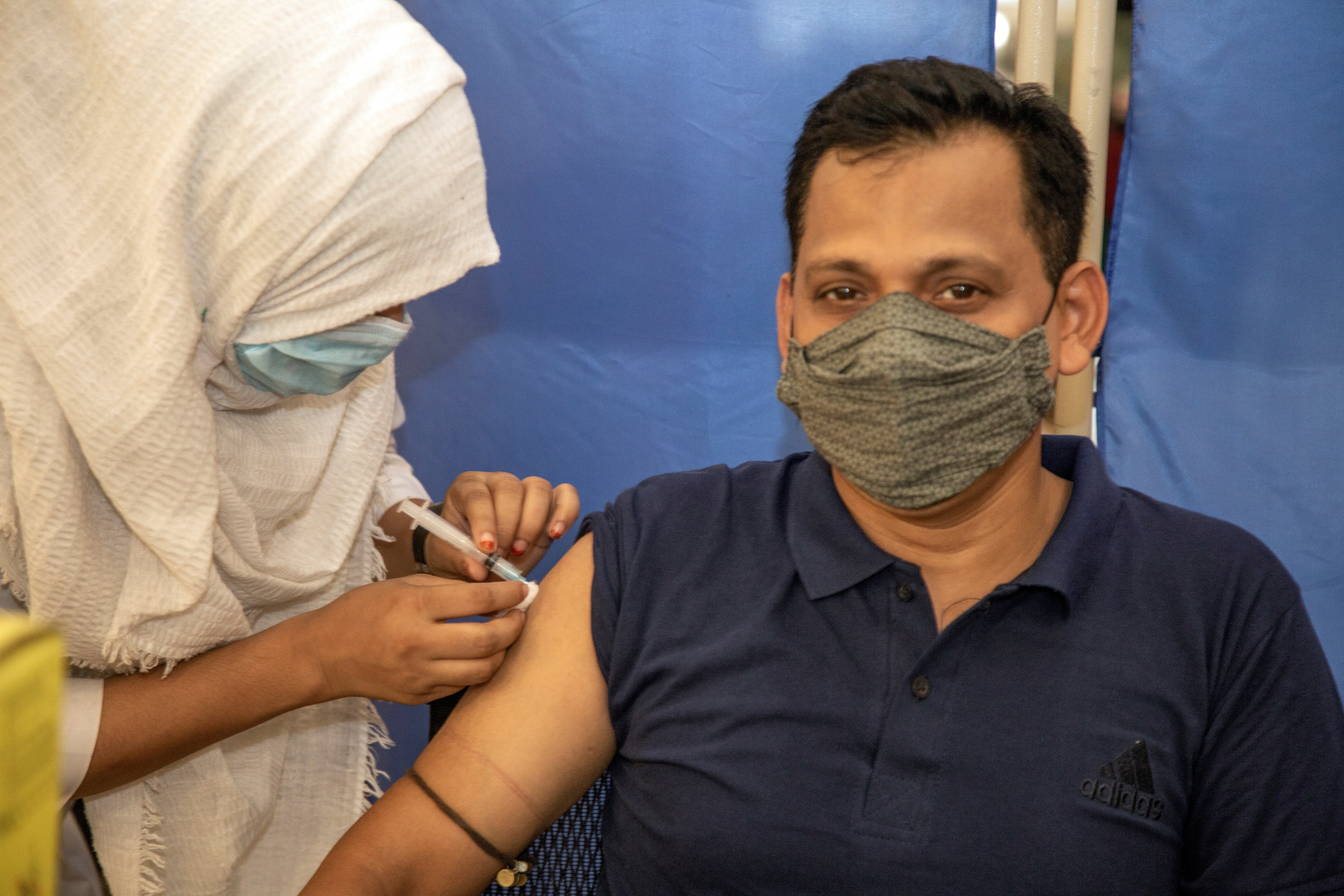 Dhaka (Bangladesh), 27/06/2021.- A man receives a second dose of Oxford-AstraZeneca Covid-19 coronavirus vaccine during a vaccination campaign at the Bangabandhu Sheikh Mujib Medical University (BSMMU) in Dhaka, Bangladesh, 27 June 2021. Bangladesh authorities imposed a nationwide all-out lockdown starting from Monday 28 June, following a spike in COVID-19 cases. EFE/EPA/MONIRUL ALAM