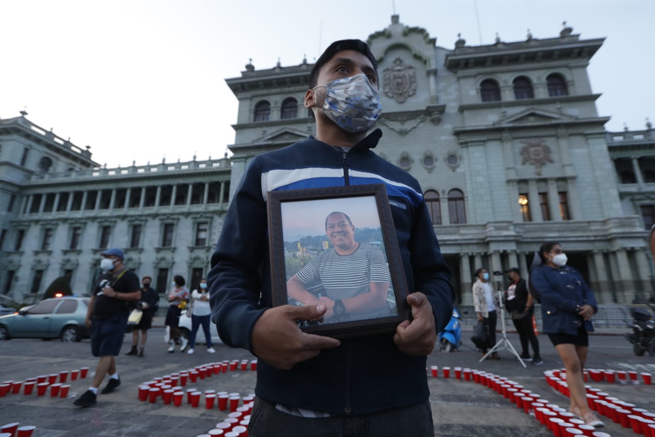 Alexander García, de 29 años, portaba una fotografía de su padre René fallecido hace un año por covid-19. (Foto Prensa Libre: Esbin García) 