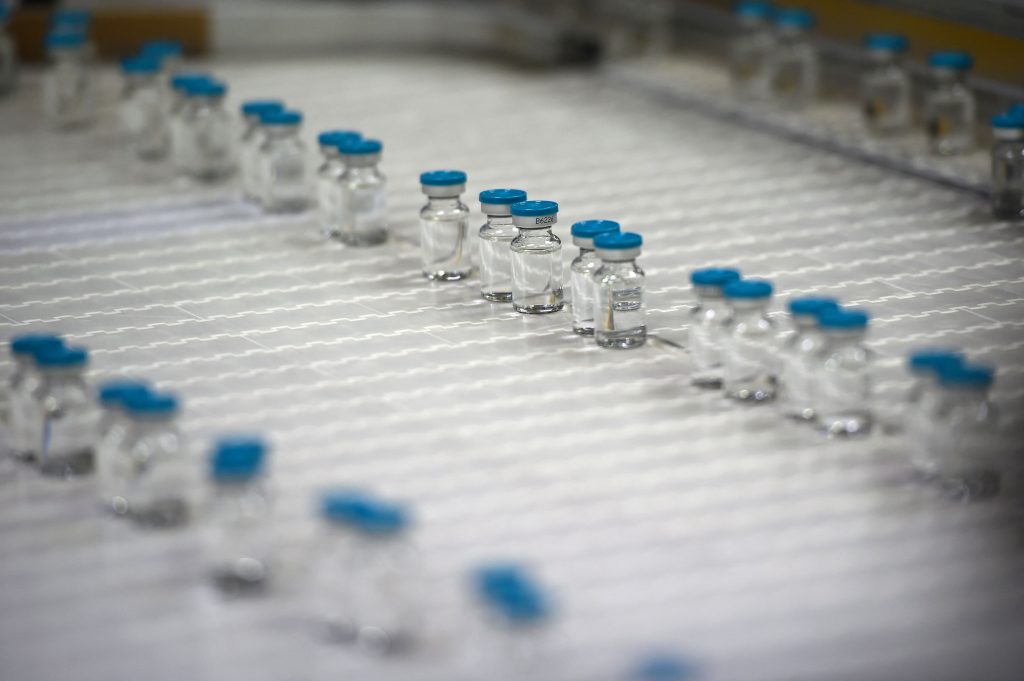 This picture taken on April 22, 2021, in Poce-sur-Cisse, Central France, shows bottles of diluent on the production line inside the pharmaceutical plant Fareva. - Fareva was chosen as the main supplier of the candidate RNA messenger vaccine from the German company CureVac. The site will therefore produce the diluent used in this vaccine. (Photo by GUILLAUME SOUVANT / AFP)