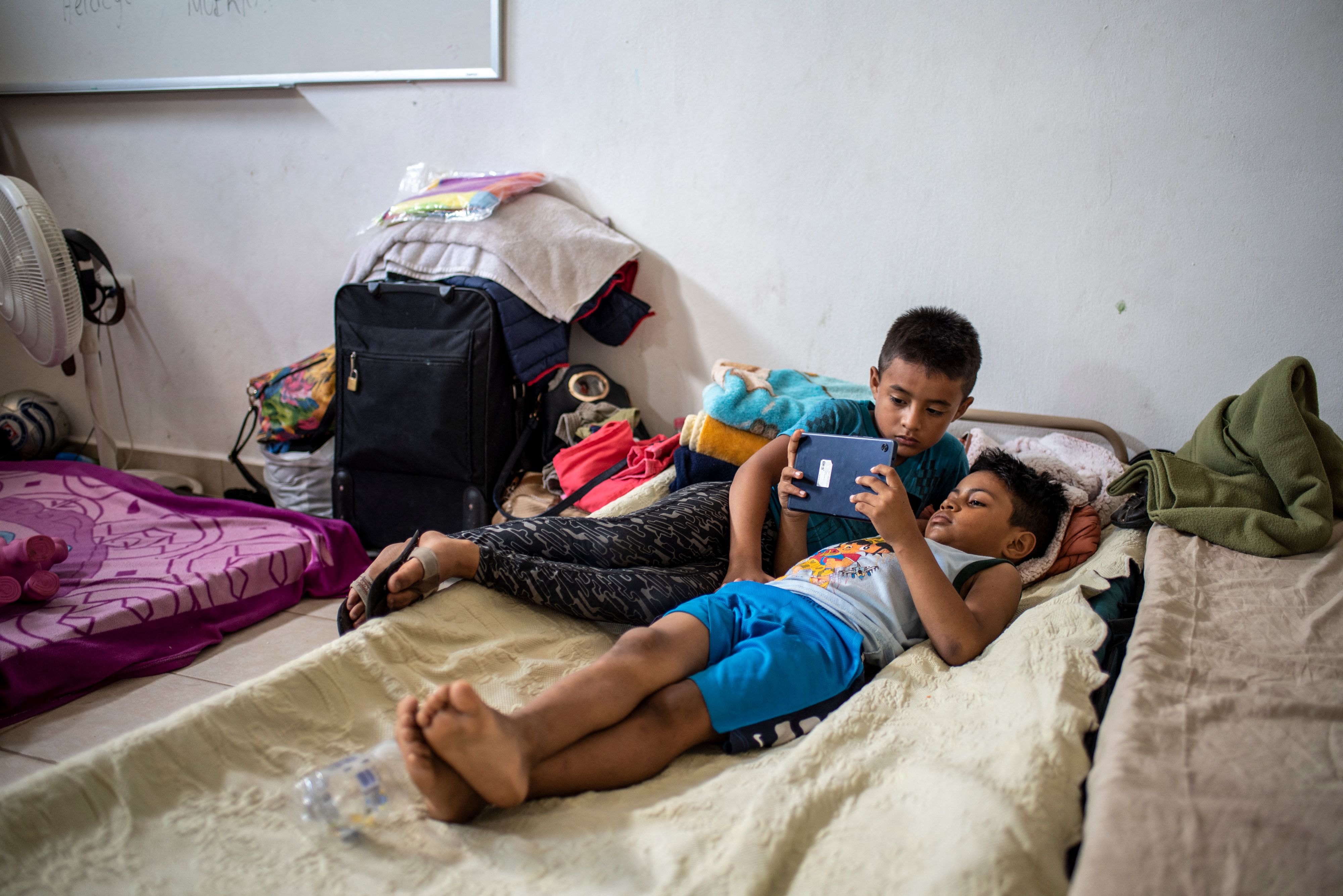 Niños migrantes reciben clases virtuales mientas se encuentran en el refugio en Matamoros. (Foto Prensa Libre: AFP)