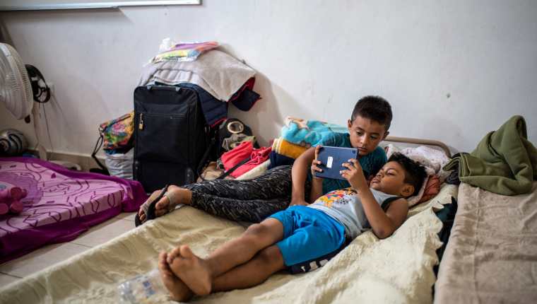 Niños migrantes reciben clases virtuales mientas se encuentran en el refugio en Matamoros. (Foto Prensa Libre: AFP)