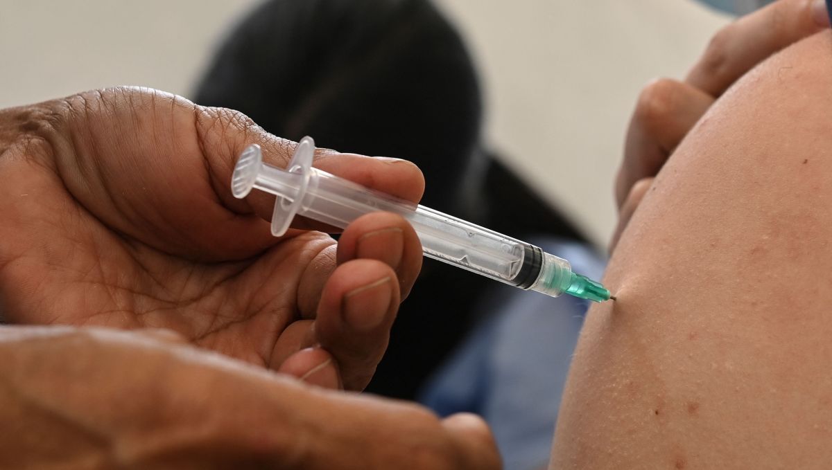 A health worker (R) receives the first dose of the CoronaVac vaccine, developed by China's Sinovac firm, during a vaccination day against COVID-19 for clinical and medical personnel from the private sector in Caracas on May 28, 2021. (Photo by Yuri CORTEZ / AFP)
