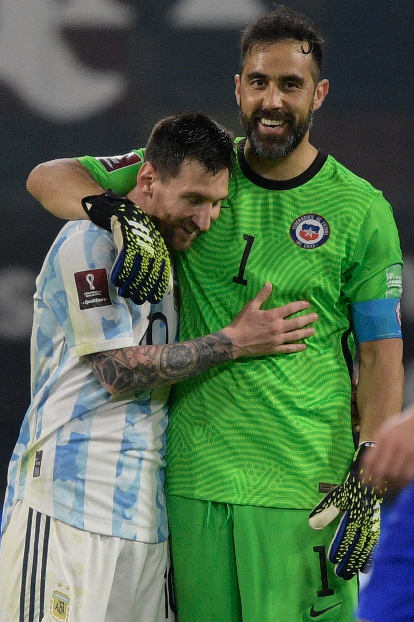 Argentina's Lionel Messi (L) and Chile's goalkeeper Claudio Bravo greet each other after tying 1-1 in their South American qualification football match for the FIFA World Cup Qatar 2022 at the Estadio Unico Madre de Ciudades stadium in Santiago del Estero, Argentina, on June 3, 2021. (Photo by Juan Mabromata / POOL / AFP)