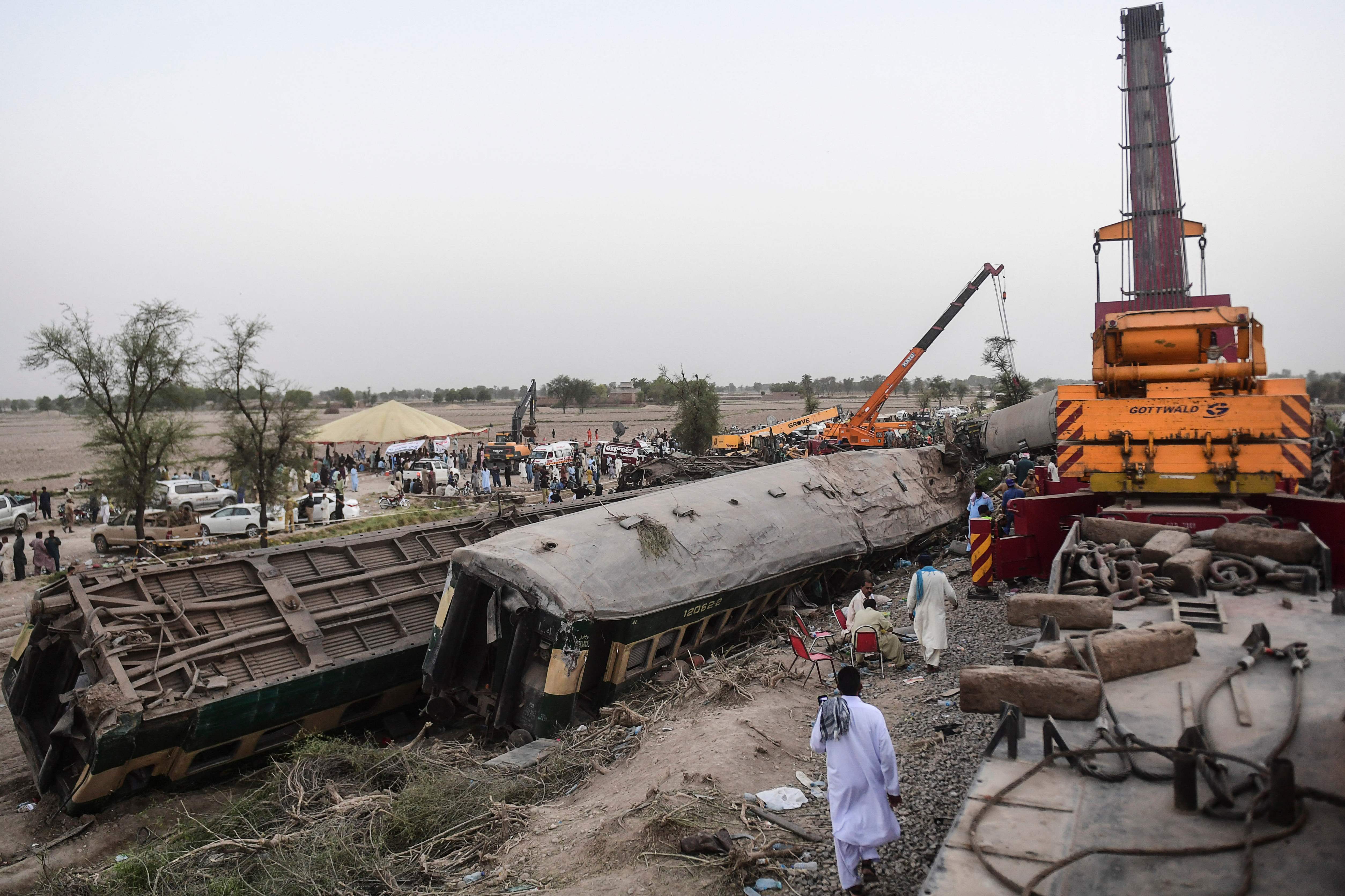 El accidente se produjo de madrugada cuando el convoy Millat Express descarriló y cayó sobre otra vía, provocando así la colisión con el Sir Syed Express. (Foto Prensa Libre: AFP)