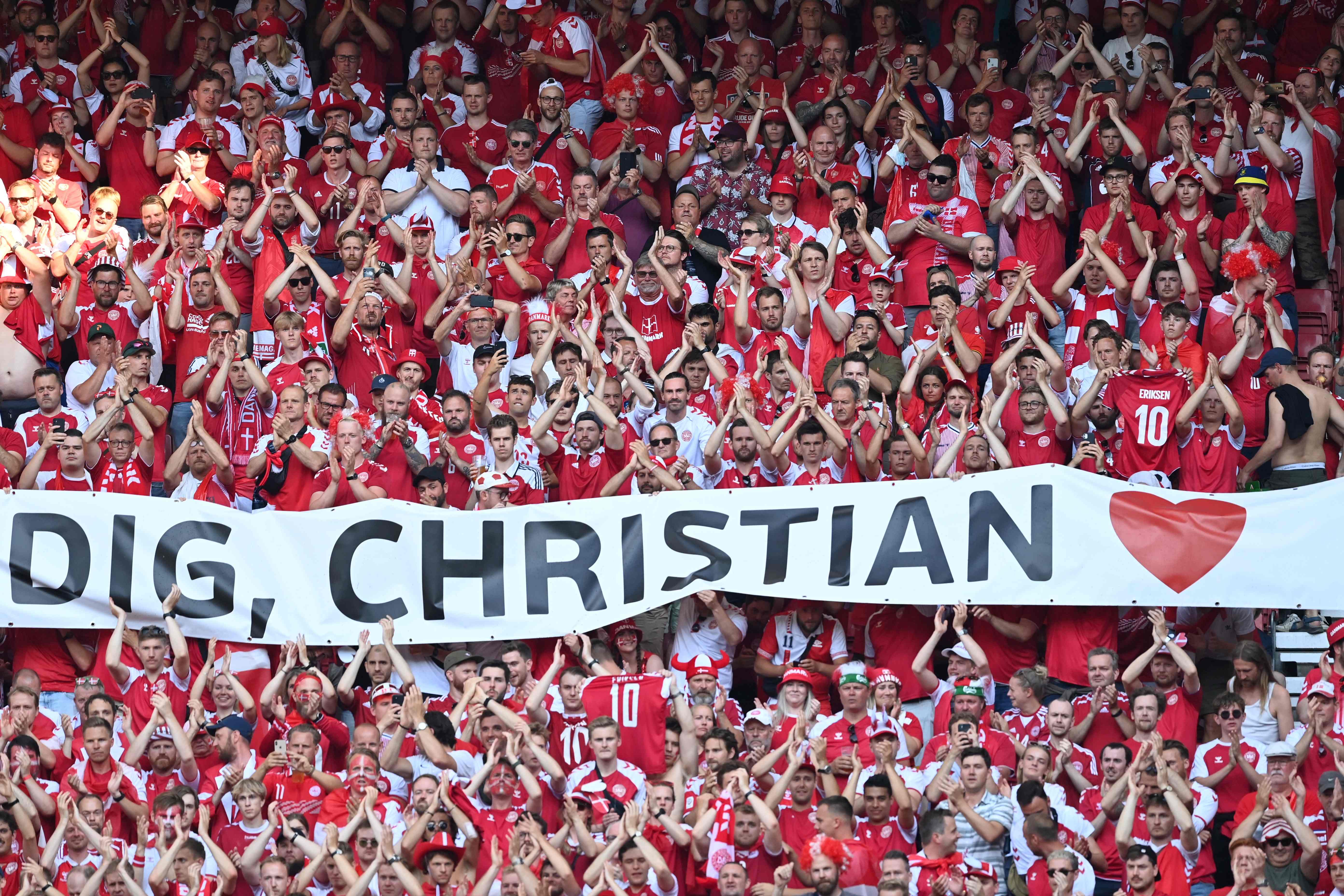 TOPSHOT - Denmark fans clap after the ball was kicked out of play in honour of Denmark's midfielder Christian Eriksen during the UEFA EURO 2020 Group B football match between Denmark and Belgium at the Parken Stadium in Copenhagen on June 17, 2021. - Eriksen suffered a cardiac arrest during his country's Euro 2020 opener last weekend. (Photo by STUART FRANKLIN / various sources / AFP)