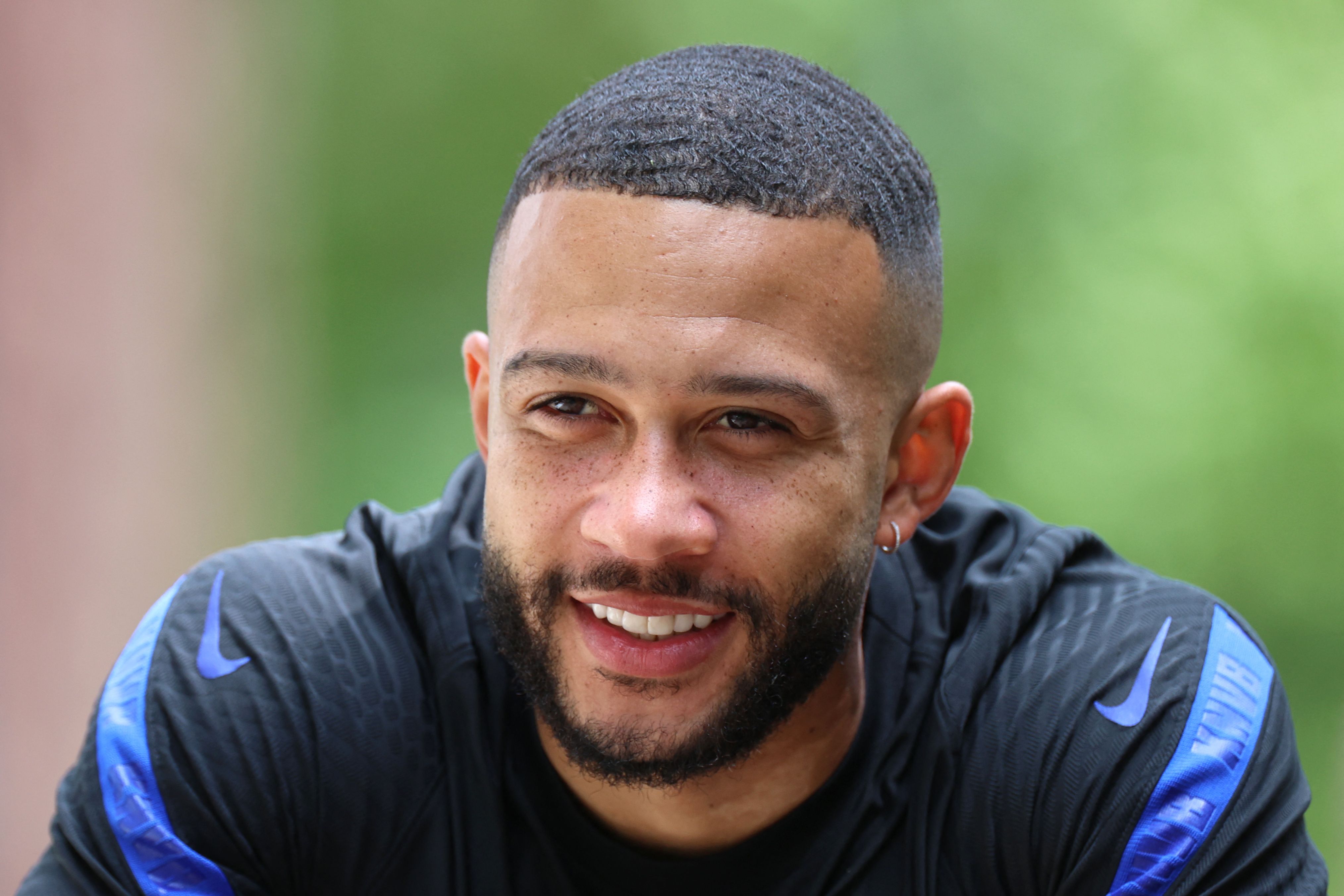 Netherlands' forward Memphis Depay smiles as he rides a bike after their MD-1 training session in Zeist on June 20, 2021 on the eve of their UEFA EURO 2020 Group C football match against North Macedonia. (Photo by KENZO TRIBOUILLARD / AFP)