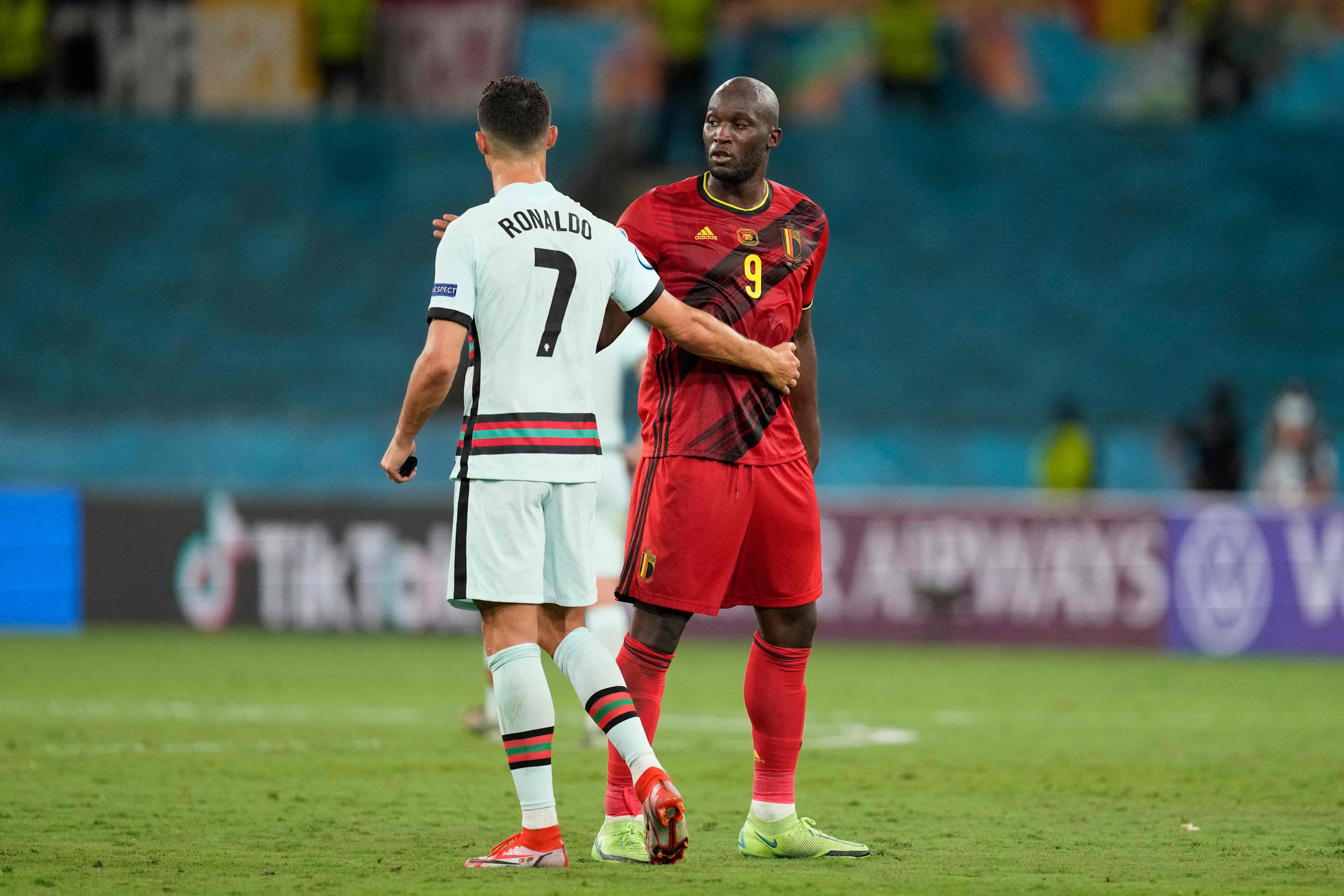 Portugal's forward Cristiano Ronaldo (L) greets Belgium's forward Romelu Lukaku at the end of the UEFA EURO 2020 round of 16 football match between Belgium and Portugal at La Cartuja Stadium in Seville on June 27, 2021. (Photo by THANASSIS STAVRAKIS / POOL / AFP)
