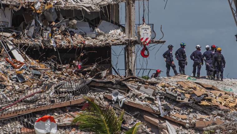 Search and Rescue teams look for possible survivors in the partially collapsed 12-story Champlain Towers South condo building on June 27, 2021 in Surfside, Florida. - The death toll after the collapse of a Florida apartment tower has risen to nine, the local mayor said on June 27, 2021, more than three days after the building pancaked as residents slept. 