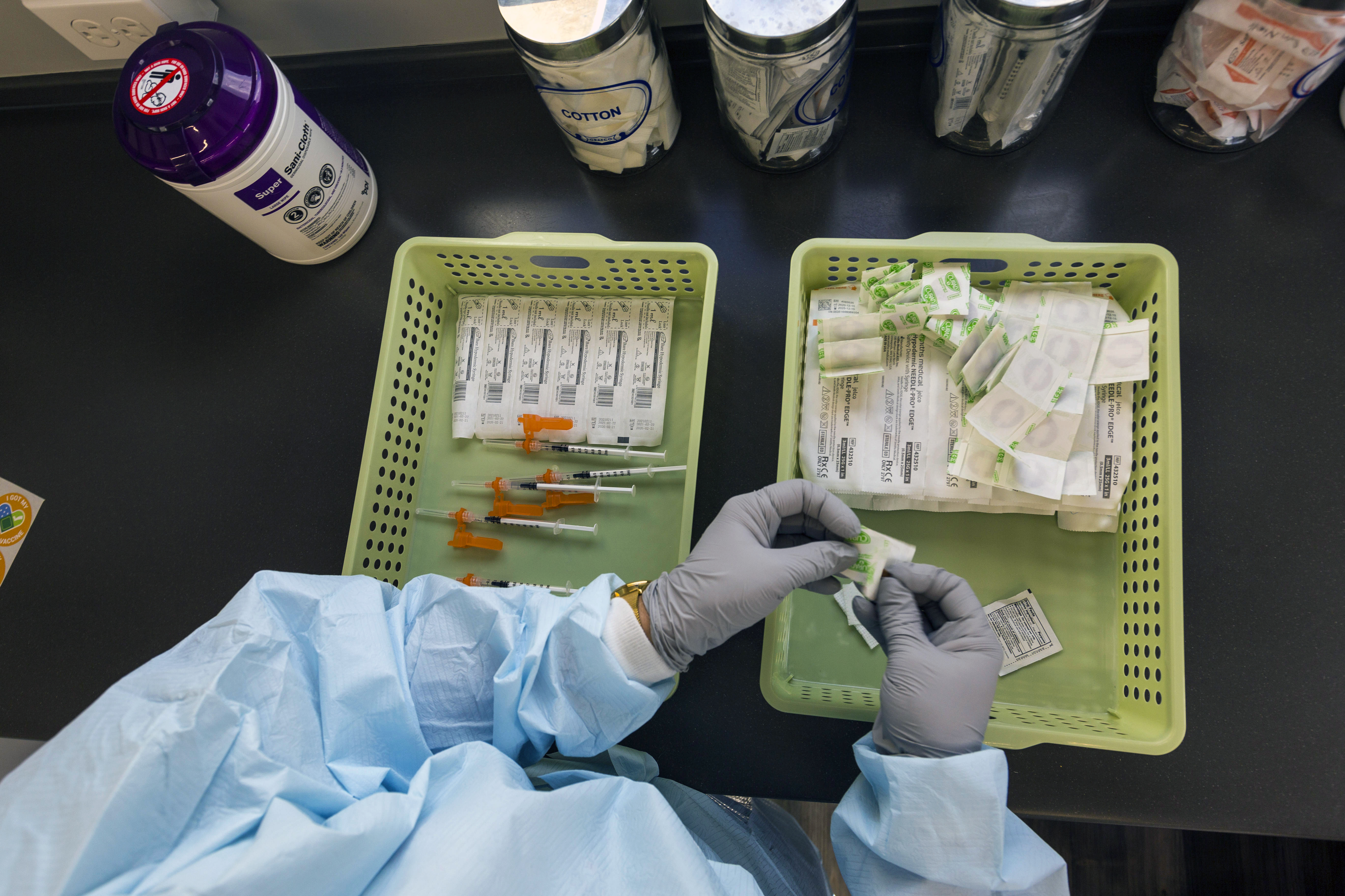 Un trabajador sanitario se prepara para administrar una dosis de la vacuna COVID-19 de Pfizer en Miami el 28 de mayo de 2021. (Foto Prensa Libre: Saul Martinez/The New York Times)