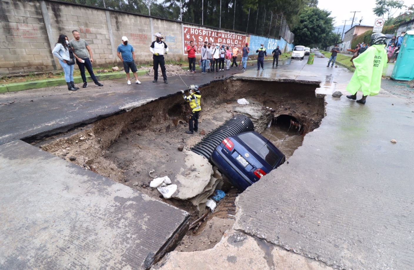 Un vehículo cayó al fondo de un hundimiento que hay desde hace varios días en la avenida Pablo VI y 2a. calle de la zona 7 de Mixco. (Foto Prensa Libre: Bomberos Voluntarios)