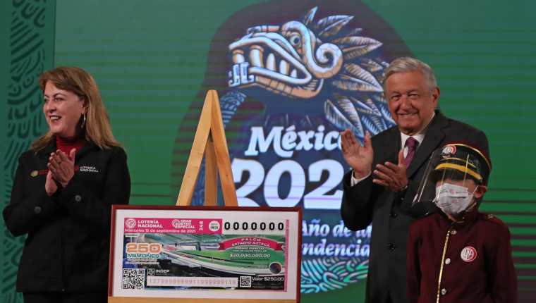 El presidente de México, Andrés Manuel López Obrador, acompañado de la directora general de la Lotería Nacional, Margarita González Saravia, develan un boleto para el sorteo del 15 de septiembre  de 2021. (Foto Prensa Libre: EFE)