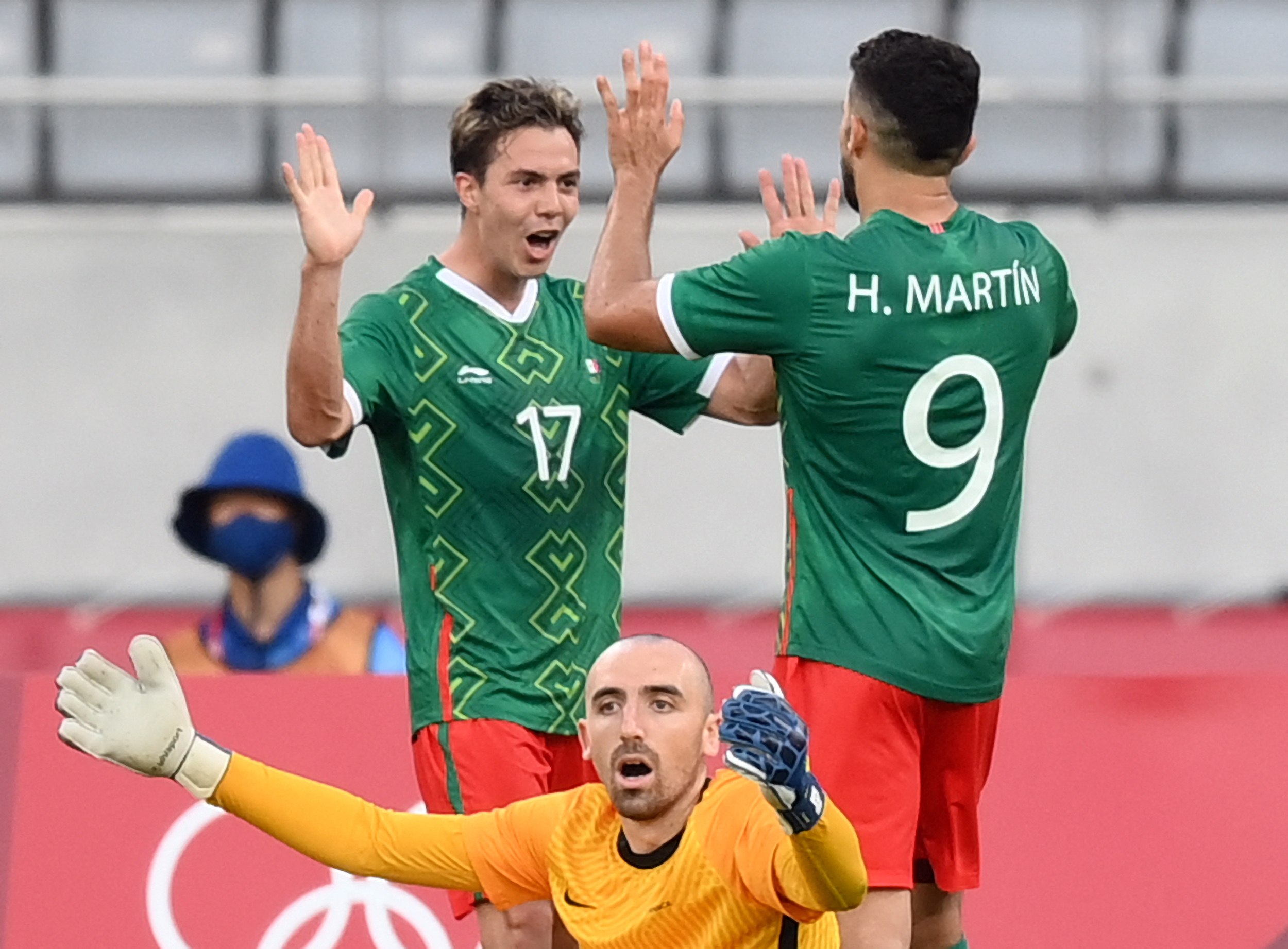 Mexico's midfielder Sebastian Cordova (L) celebrates scoring Mexico's second goal as France's goalkeeper Paul Bernardoni (BOTTOM) reacts during the Tokyo 2020 Olympic Games men's group A first round football match between Mexico and France at Tokyo Stadium in Tokyo on July 22, 2021. (Photo by FRANCK FIFE / AFP)