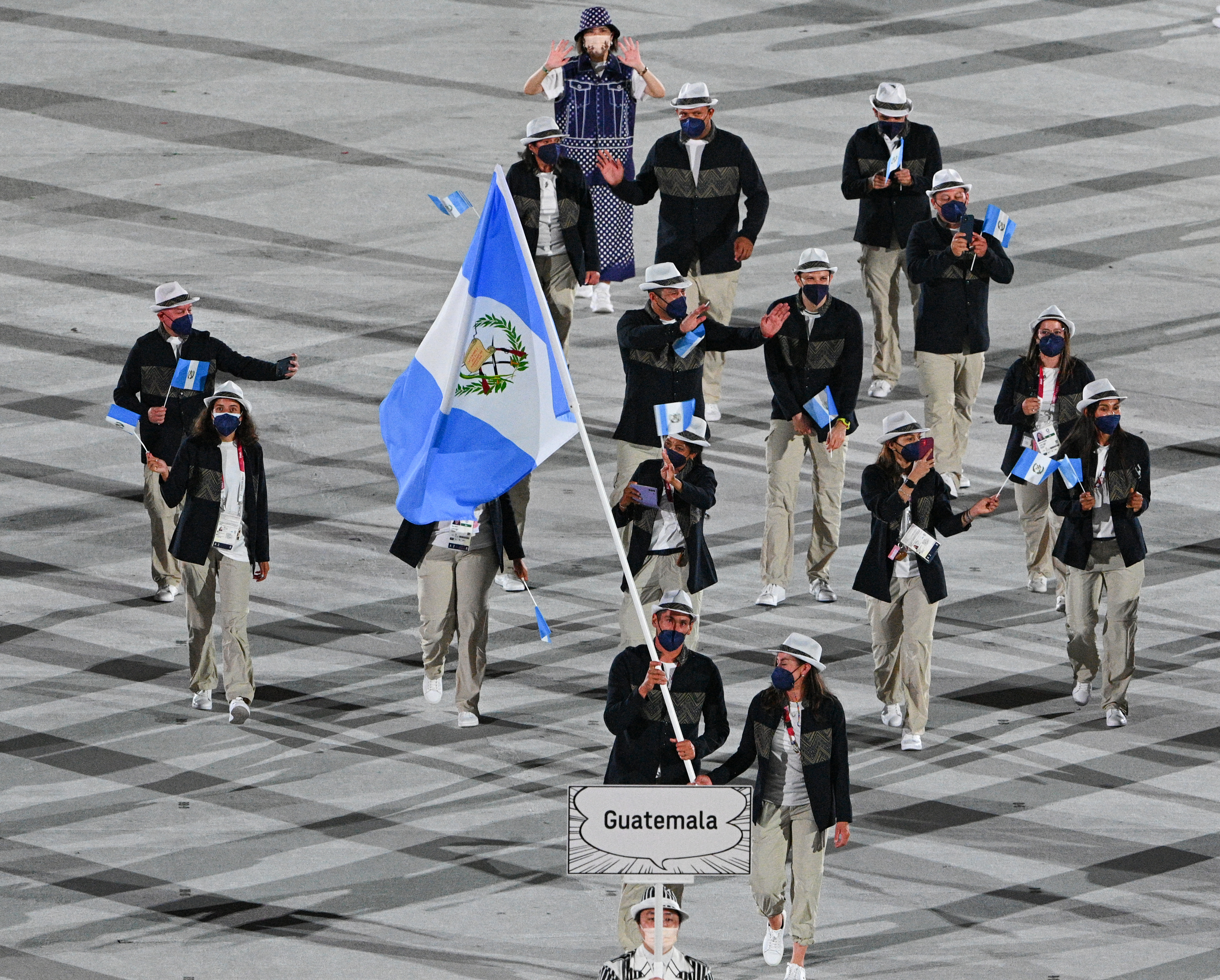 Guatemala's flag bearer Isabella Maegli and Guatemala's flag bearer Juan Maegli and their delegation parade during the opening ceremony of the Tokyo 2020 Olympic Games, at the Olympic Stadium, in Tokyo, on July 23, 2021. (Photo by Martin BUREAU / AFP)