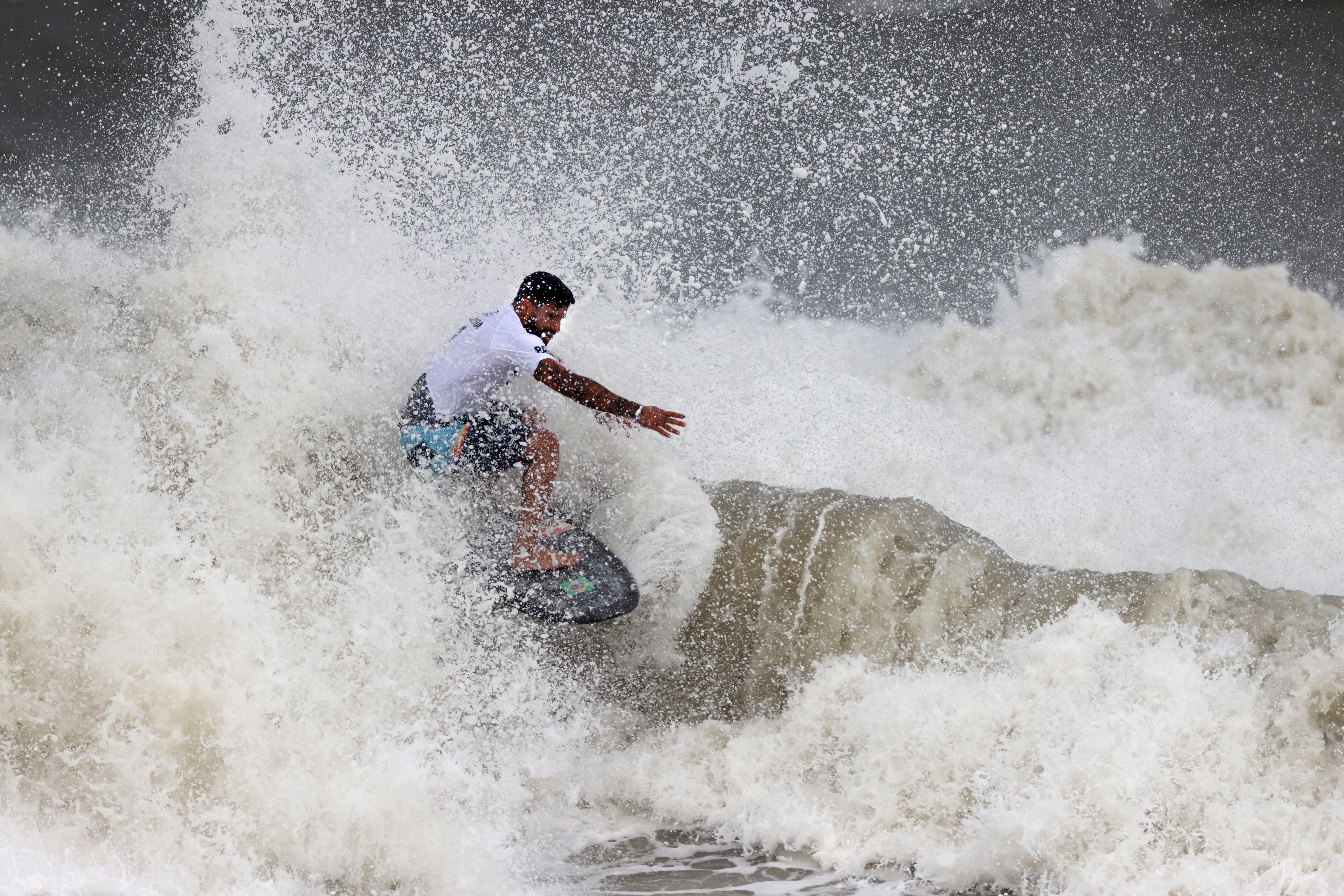 El brasileño Italo Ferreira durante la competencia de surf en la playa de  Tsurigasaki en Chiba. El sudamericano ganó medalla de oro. Foto Prensa Libre: AFP.