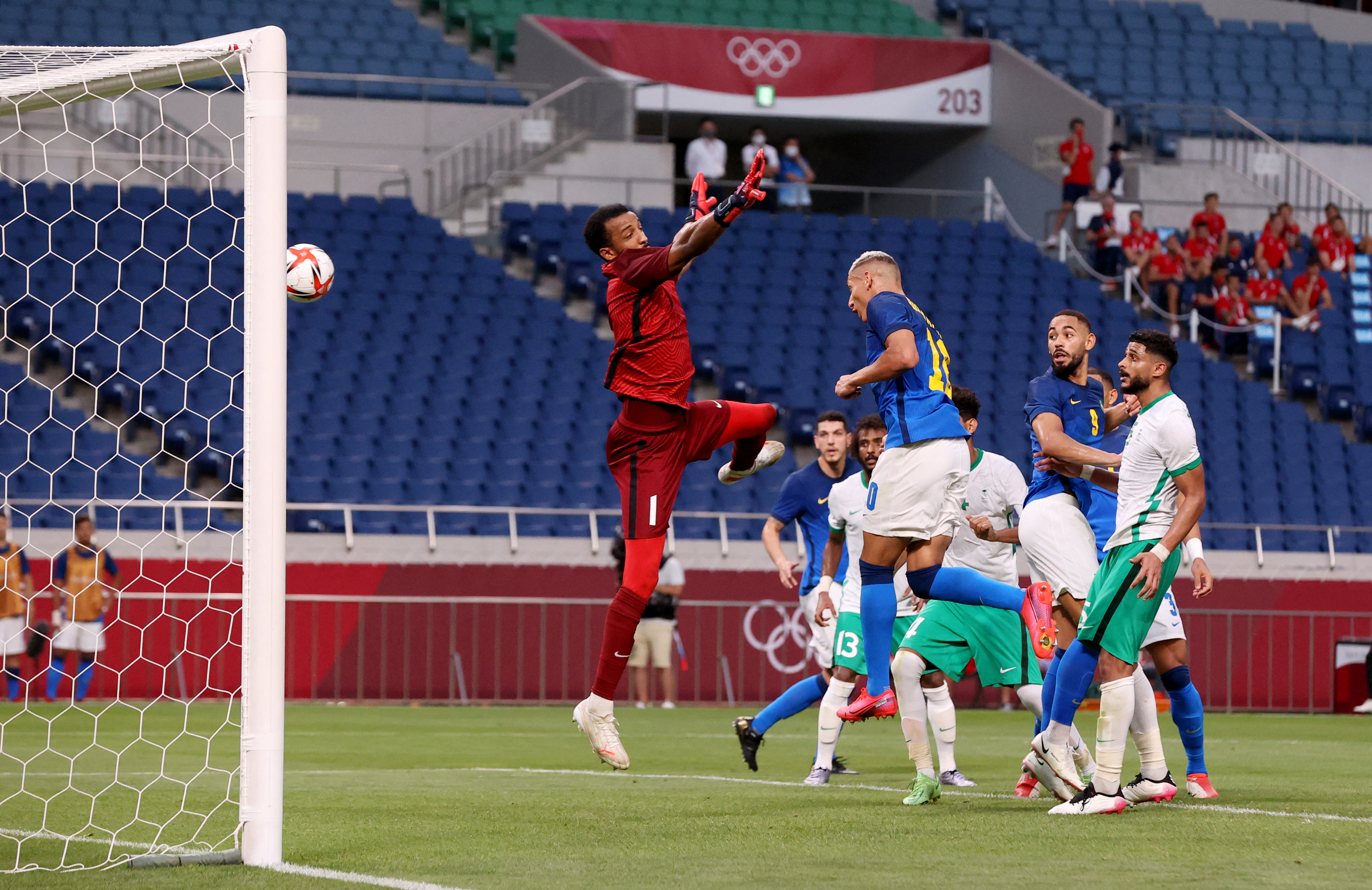El delantero de Brasil, Richarlison,(de azul) cabecea ante l portero saudí Amin Bukhari. Foto Prensa Libre: AFP.