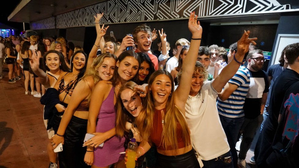 Clientes en la cola para entrar en un club nocturno en Brighton, Inglaterra, celebran el fin de las restricciones. Getty Images