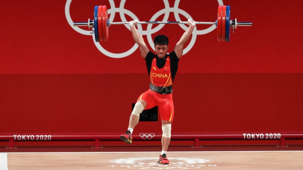 El pesista chino Li Fabin sostiene 166 kilos con una sola pierna.