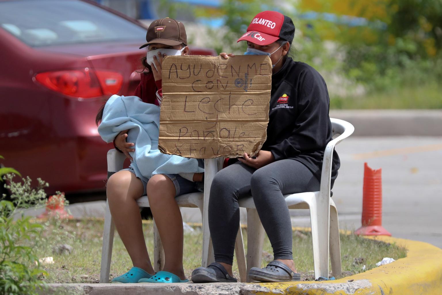 AME9774. TEGUCIGALPA (HONDURAS), 30/06/2020.- Dos mujeres piden dinero para alimentar a sus hijos este martes, en Tegucigalpa (Honduras). El fenómeno de las caravanas de migrantes, que comenzó en octubre de 2018 en Honduras, ha representado un cambio en el sistema migratorio de Centroamérica, México y Estados Unidos y puso en evidencia 