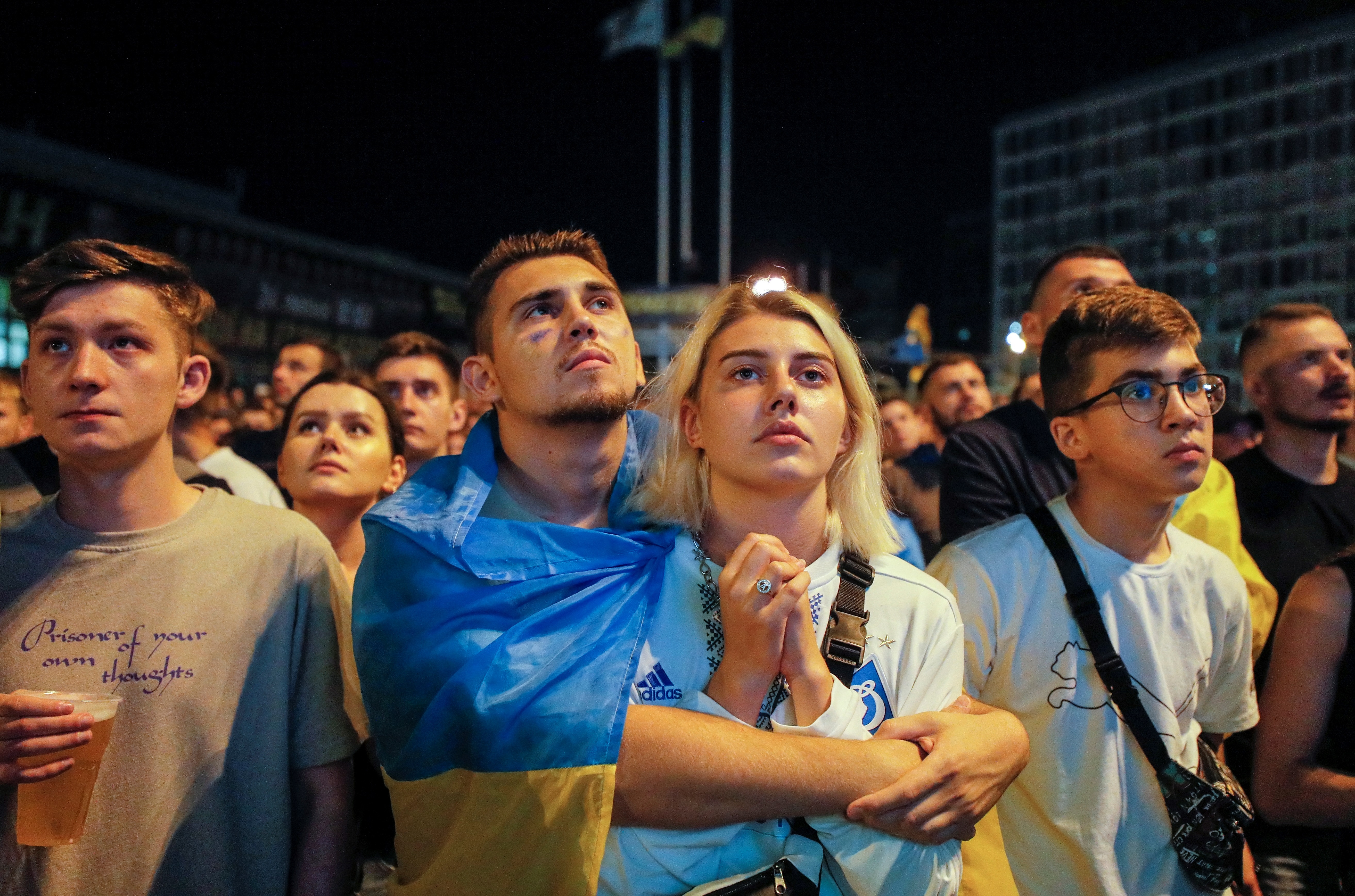 Aficionados ucranianos tristes por la derrota y salida de su equipo a manos de Inglaterra durante la Eurocopa. (Foto Prensa Libre: EFE)